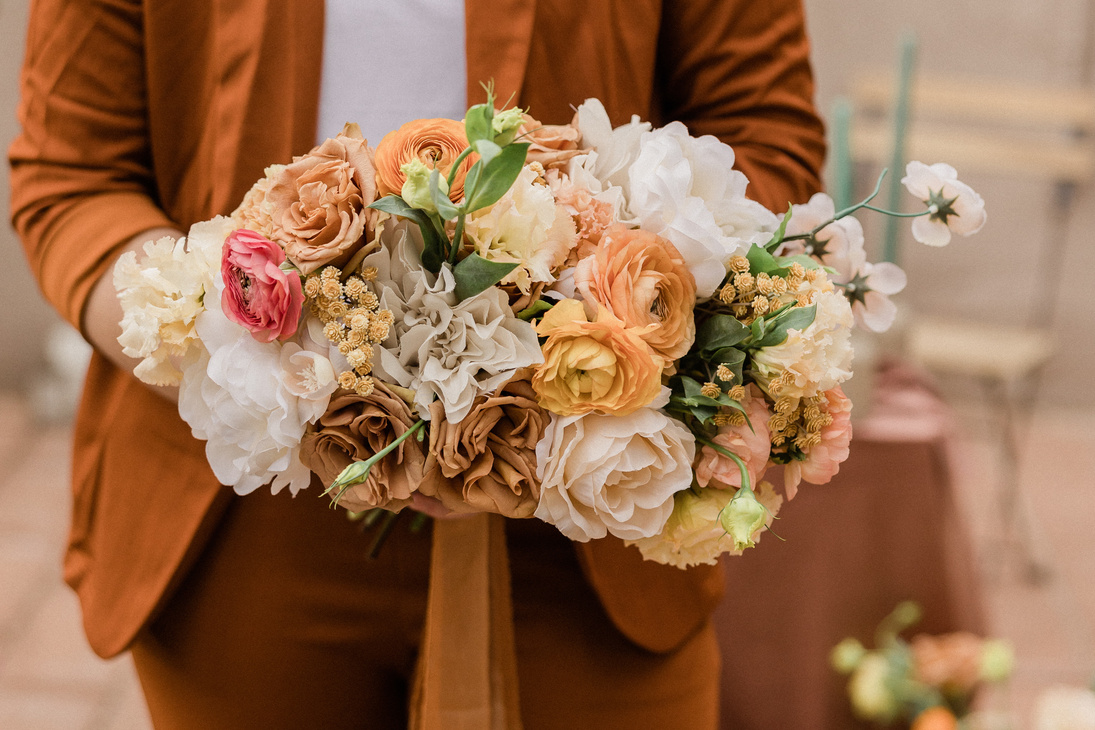 Bride in Rustic Brown Suit Holding Neutral Floral Bouquet